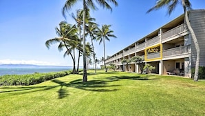 A hotel with a balcony on the second floor, a sign with the number A202, and a view of the ocean. - Oceanfront, AC!, king bed, kayaks, pickleball, and beach stuff all included! (Kaunakakai)