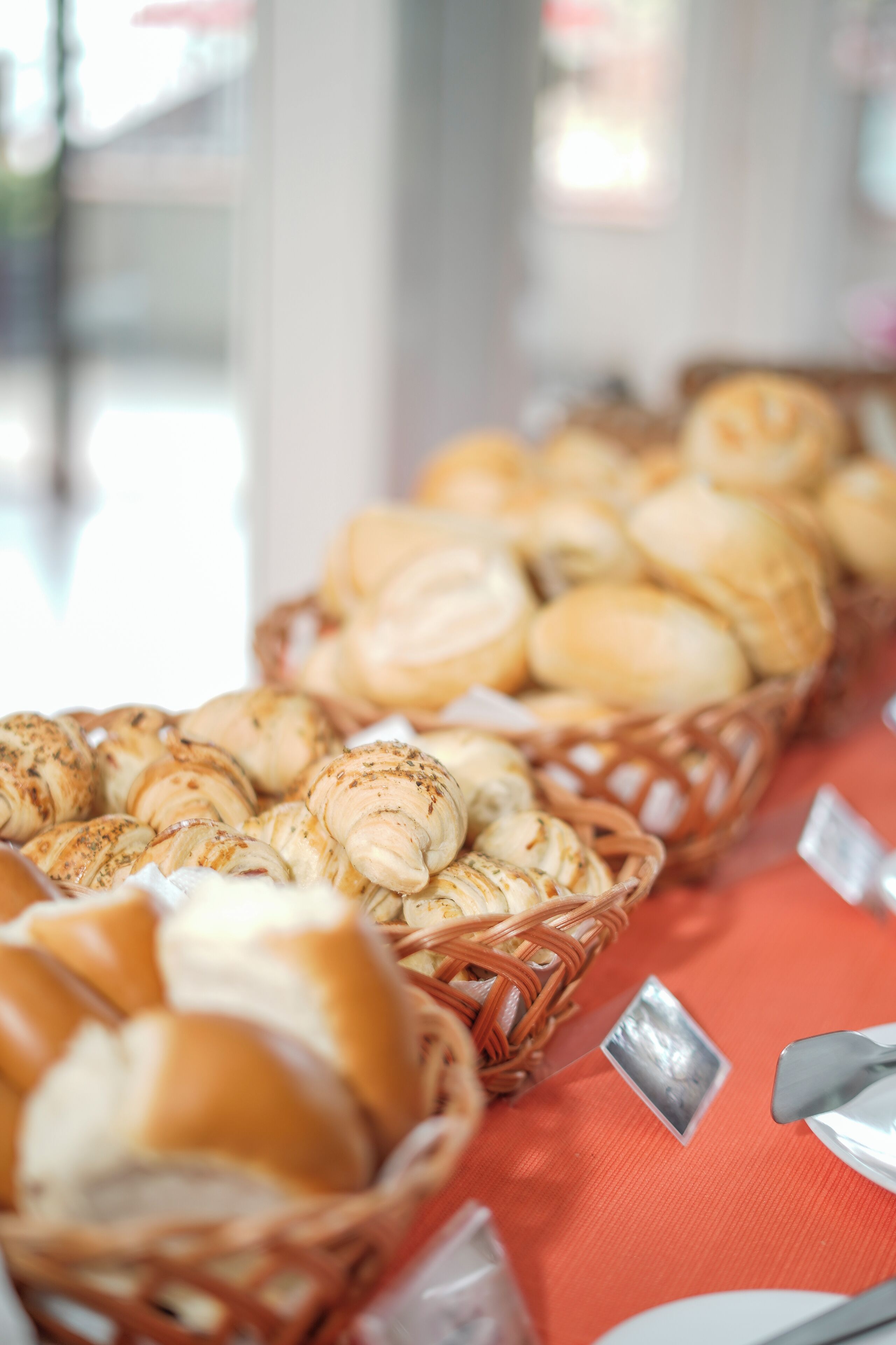 A table with baskets of pastries and a spoon.
