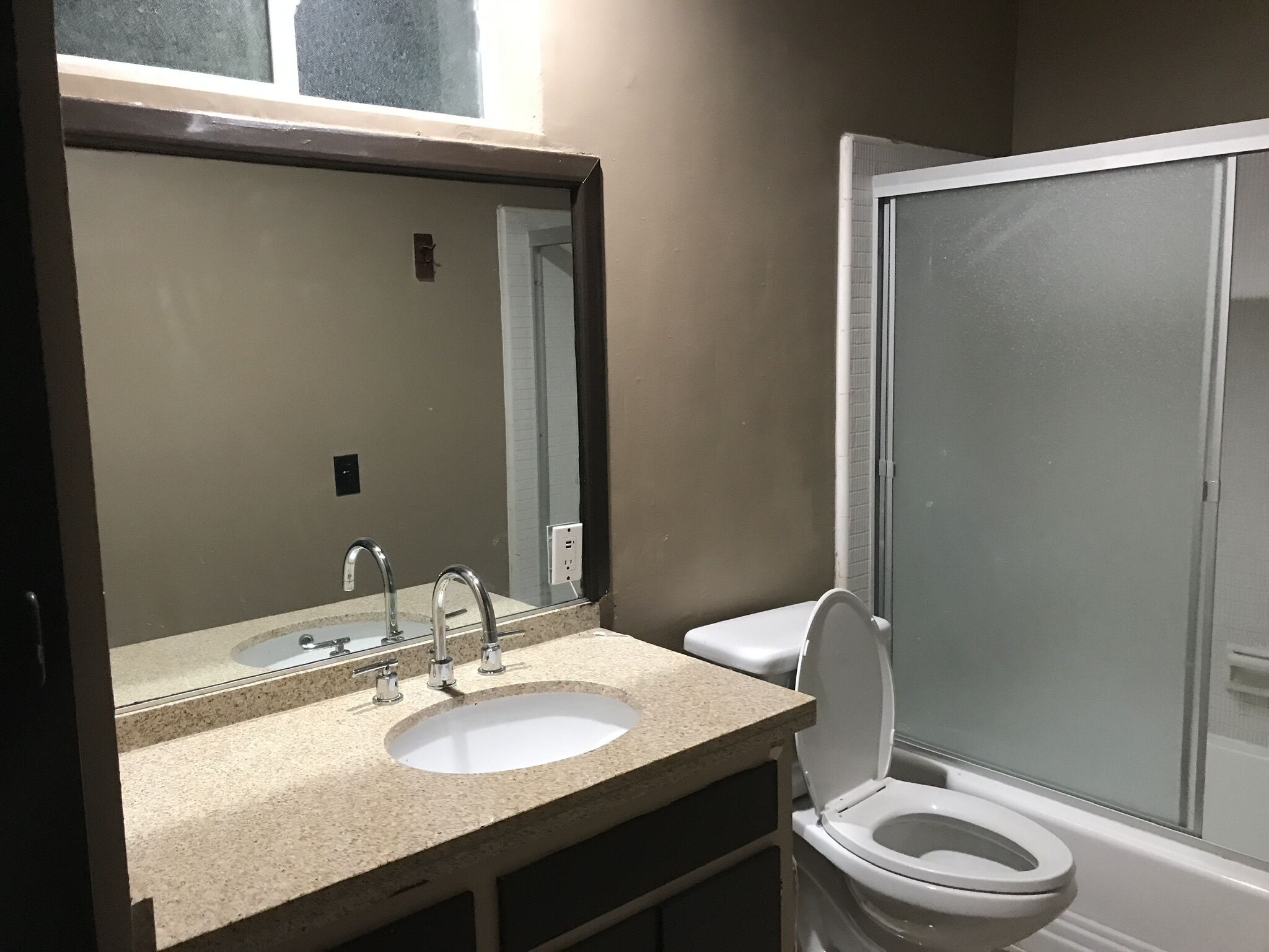 A bathroom with a sink, mirror, and toilet.