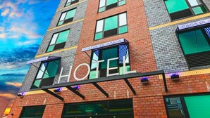 Een hotel met meerdere verdiepingen en een opvallend “HOTEL” bord op de gevel.