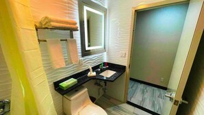 Een moderne badkamer met een wit toilet, een zwart aanrechtwastafeltje en een spiegel erboven.