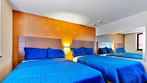 Een hotelkamer met twee bedden, houten hoofdborden en een grote spiegel aan de muur.