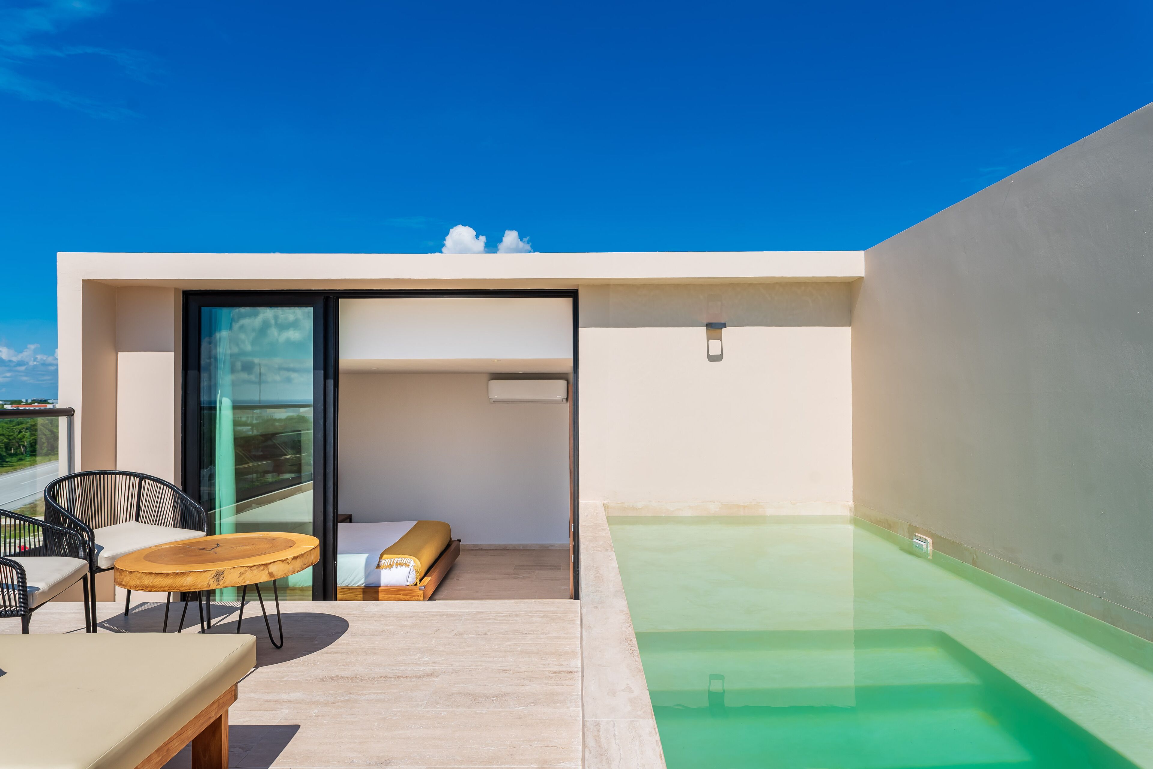 A modern outdoor living area with a pool, a sofa, and a table.