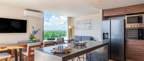 Una cocina moderna con una isla central, electrodomésticos integrados y un comedor con vistas.