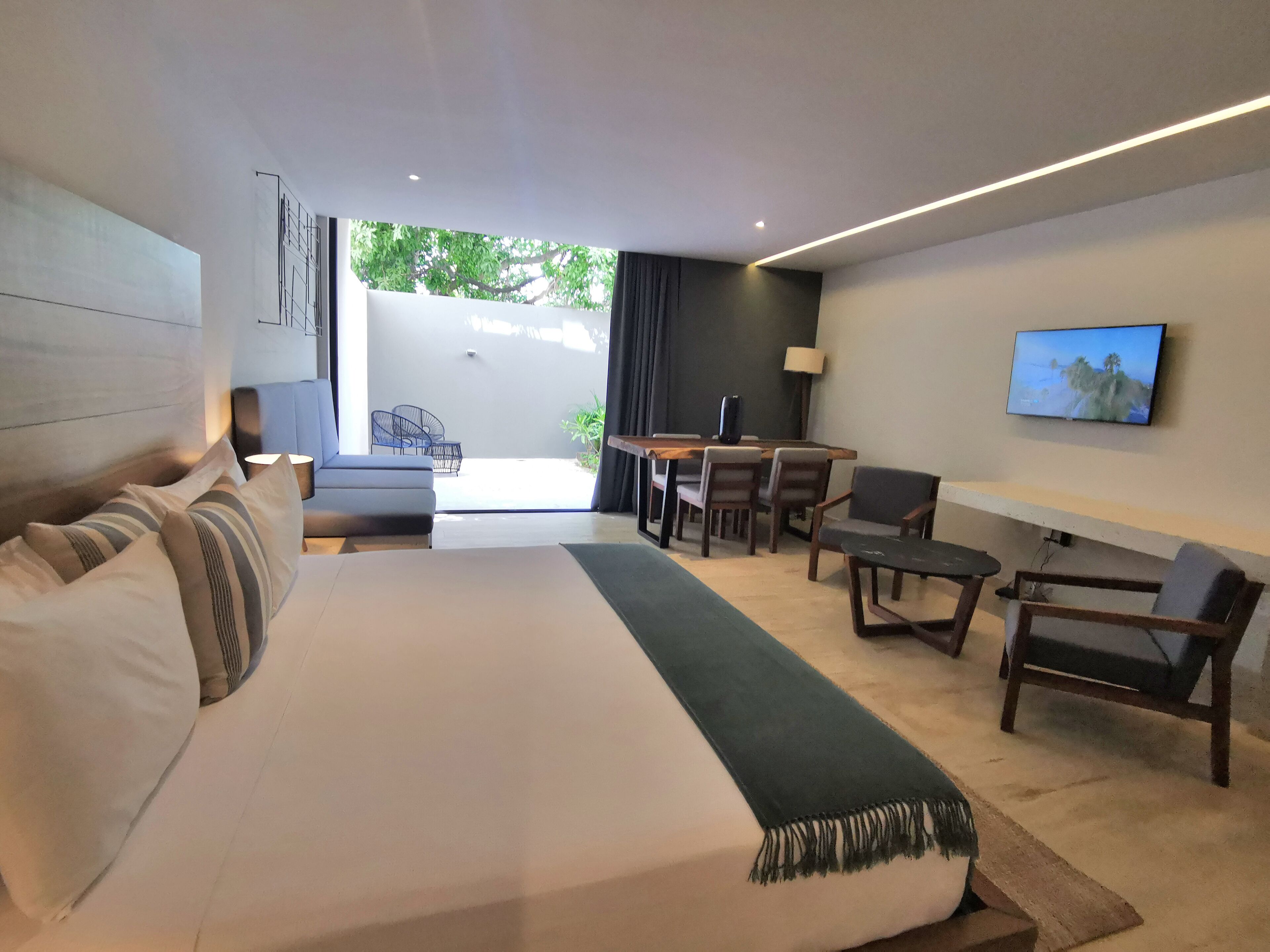 Une chambre d’hôtel moderne dotée d’un grand lit, d’un bureau et d’un coin salon.