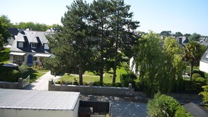 Ein Wohngebiet mit Häusern, einem großen Baum und einer Steinmauer.
