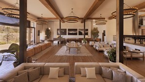 Un salon spacieux avec une grande table à manger, plusieurs canapés et une vue sur l’extérieur.