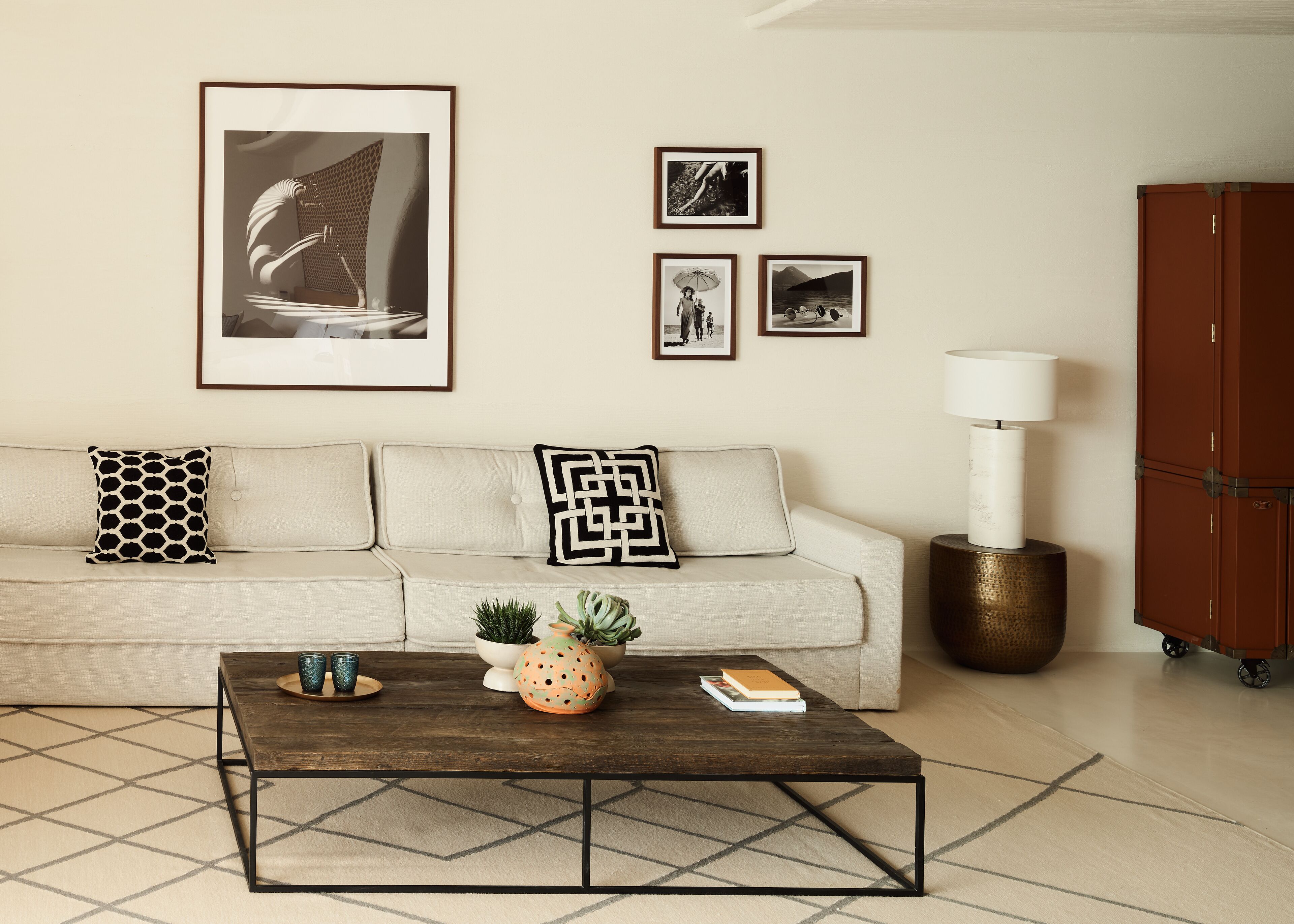 Una sala de estar con sofá, mesa de centro y decoración en la pared.