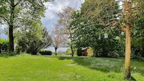 A lush green park with mature trees and a clear sky. - Charme et Tradition (trefumel)