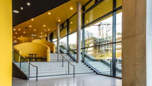 A spacious lobby with a staircase, large windows, and a modern design. - Prize by Radisson, Bonn City (Bonn)