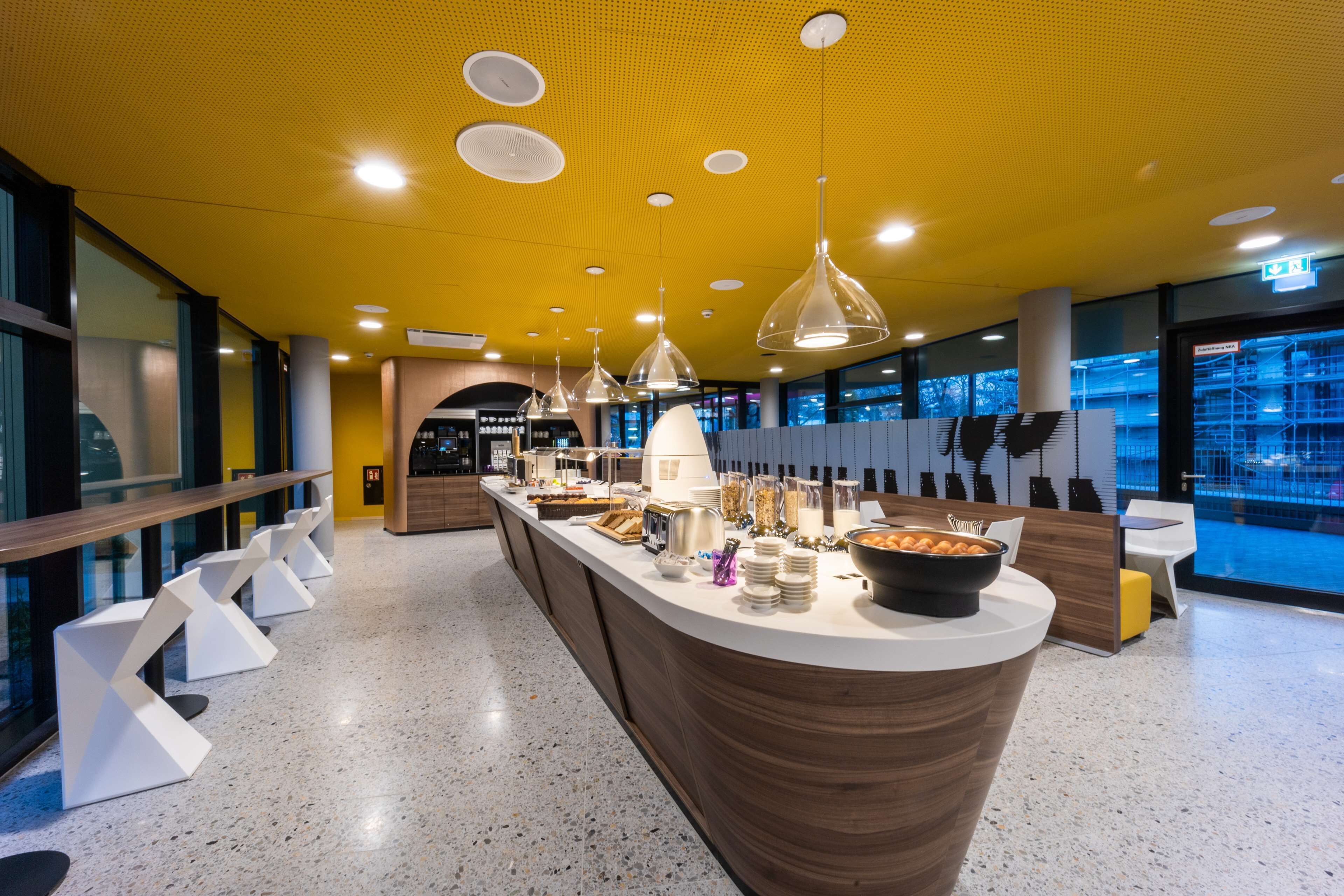 Una barra de desayuno moderna con diversas opciones de comida y diferentes disposiciones de asientos.