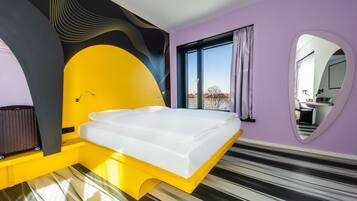 Une chambre à coucher moderne avec un lit, une fenêtre et un miroir de salle de bain.