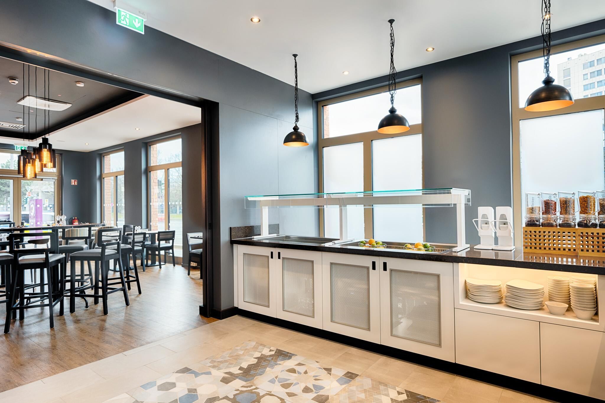 Una cucina moderna con una vetrina, un'area buffet e un angolo relax con sgabelli da bar.