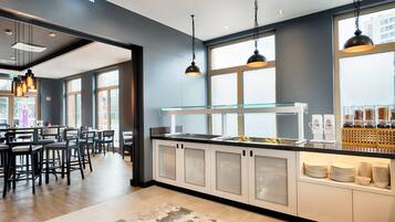 A modern kitchen with a glass display case, a buffet area, and a seating area with bar stools.