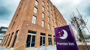 Un edificio alto de ladrillo con un llamativo letrero de Premier Inn.