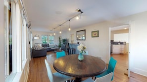 Een moderne woonkamer met een eettafel, bank en keukenhoek.