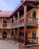 A multi-story building with wooden balconies and a red roof.