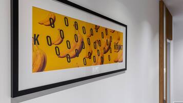 A framed artwork with bananas and numbers on a white wall.