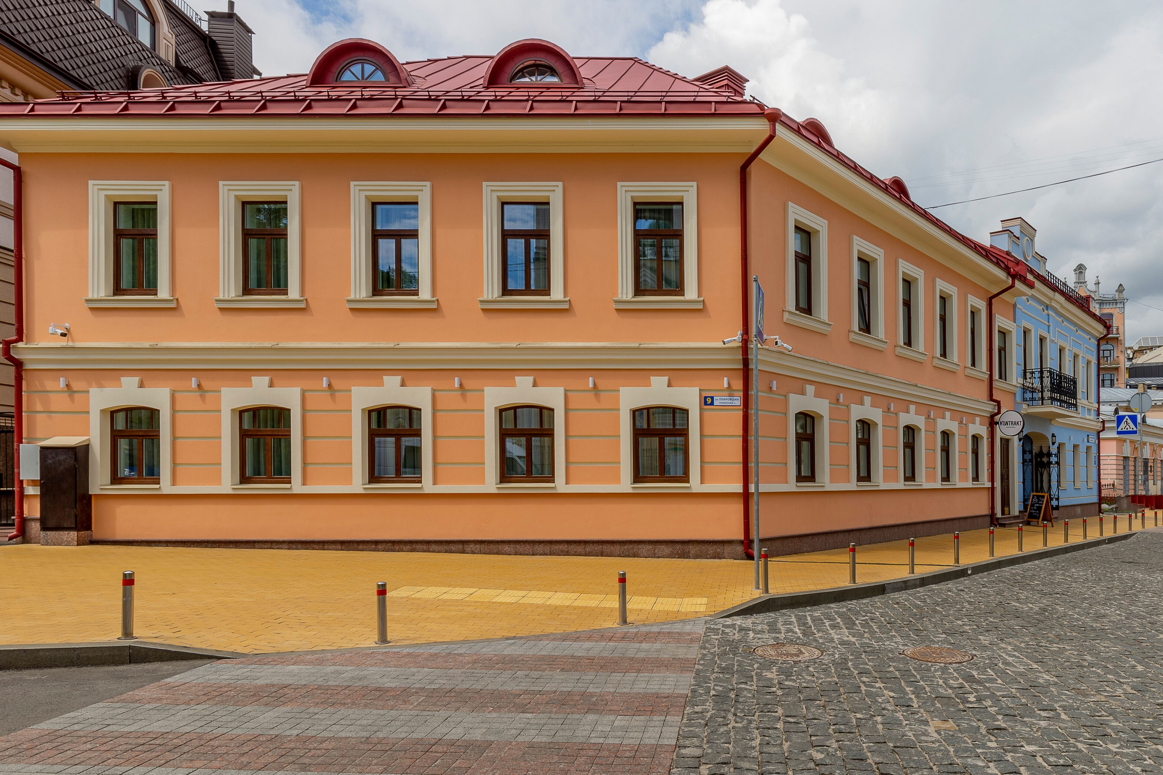 A two-story building with a peach facade and red roof.