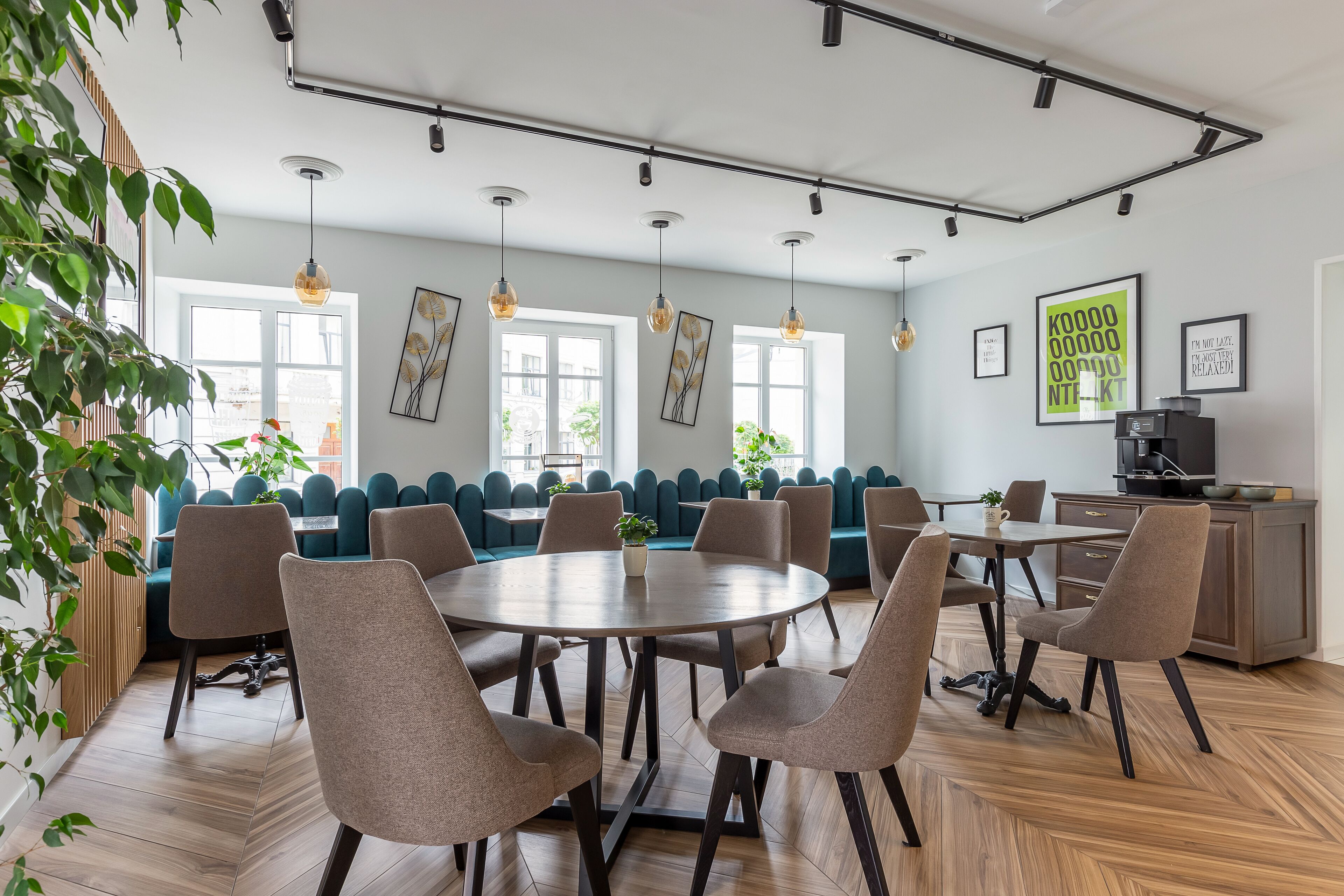 Un comedor moderno con una mesa redonda, varias sillas y un sofá azul.