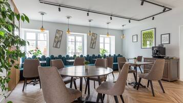 Un comedor moderno con una mesa redonda, varias sillas y un sofá azul.