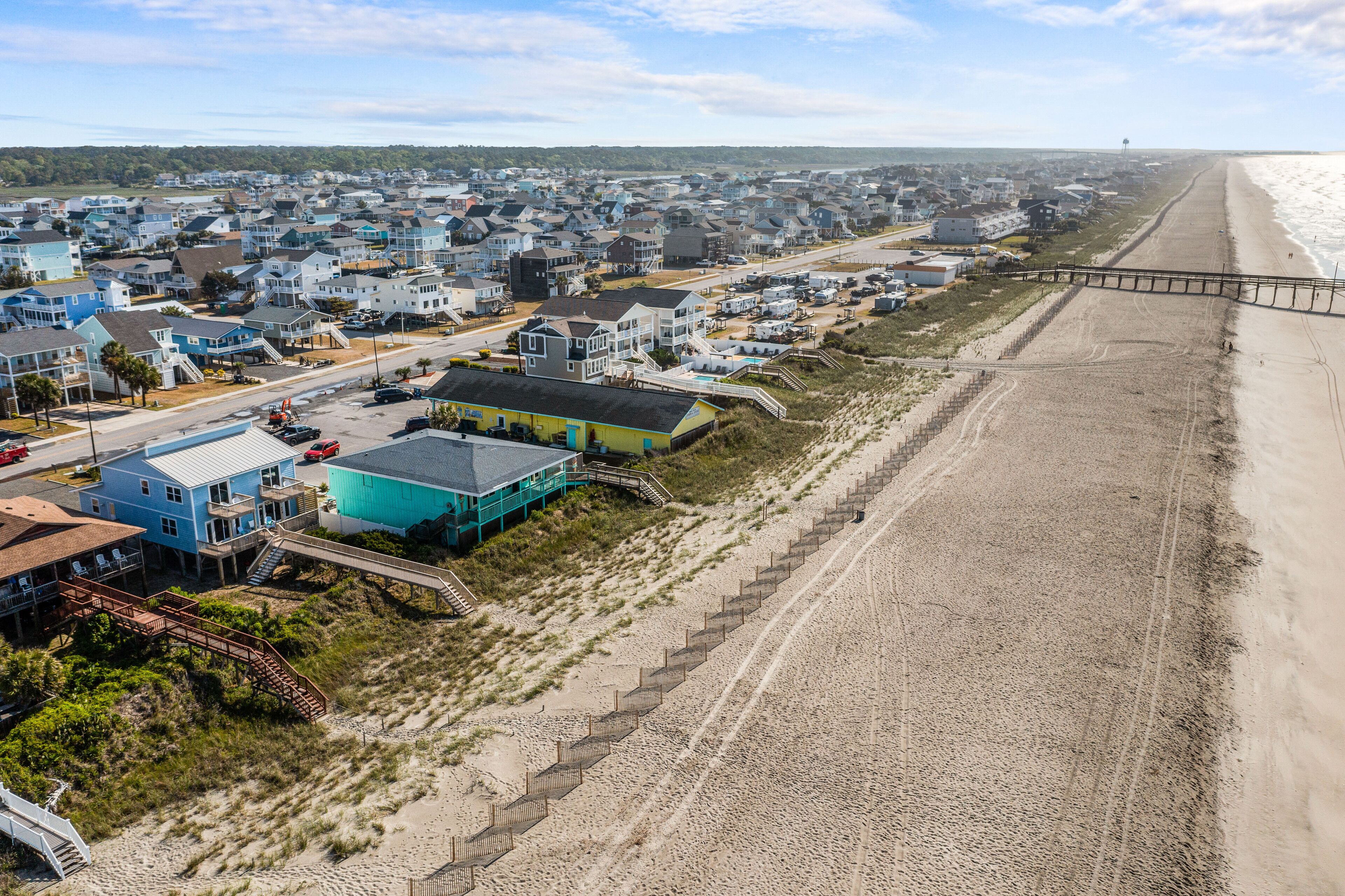 Une zone résidentielle côtière comprenant des maisons, une plage et une promenade en bord de mer.