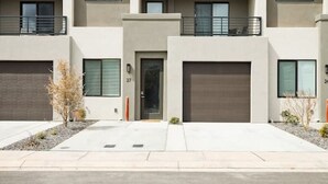 A modern multi-story residential building with a flat roof, large windows, and a clean, minimalist design. - Large Home Sleeps 16-Pool Perfect For Family Fun! (St. George)