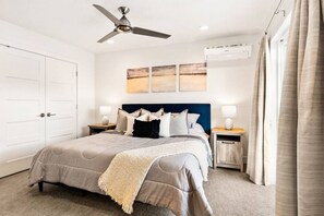 A bedroom with a bed, a ceiling fan, bedside tables, and artwork on the wall. - Large Home Sleeps 16-Pool Perfect For Family Fun! (St. George)