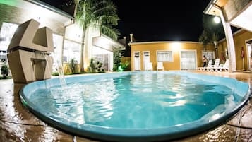 Alberca al aire libre y camastros