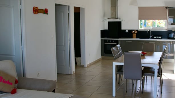 Eine moderne Küche mit Herd, Mikrowelle und Essbereich mit Stühlen und Tisch.