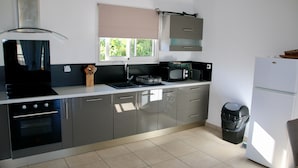 Eine moderne Küche mit Herd, Spüle, Mikrowelle und Kühlschrank.
