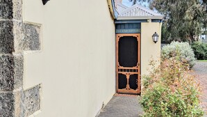 Um edifício com uma placa que diz "PEA SOUP COTTAGE" e uma porta de madeira com decoração.