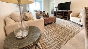 Ein Wohnzimmer mit Sofa, Sessel, Couchtisch und TV-Schrank.