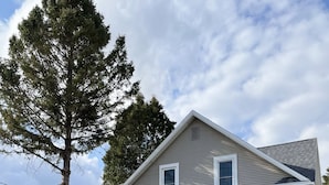 Une maison à deux étages avec une entrée à l’avant, un porche couvert et une allée.
