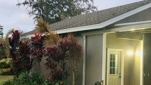 A residential building with a garage door, surrounded by lush greenery and a well-maintained lawn.