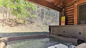 A hot tub area with a view of a forested hillside. - Cozy Log Cabin w/ Hot Tub & Fire Pit! (Sevierville)