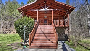 A wooden cabin with a porch and stairs leading to a door. - Cozy Log Cabin w/ Hot Tub & Fire Pit! (Sevierville)