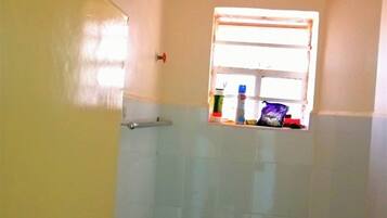 Een douche, handdoeken, zeep, toiletpapier