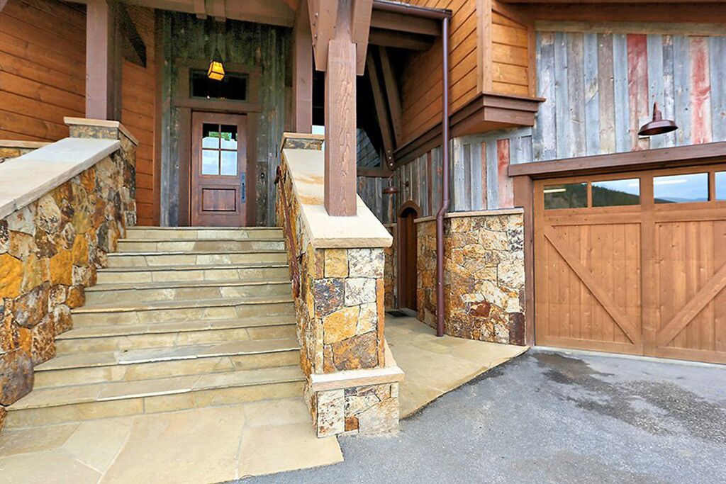 Una casa de madera con escalones de piedra que conducen a una puerta de madera.