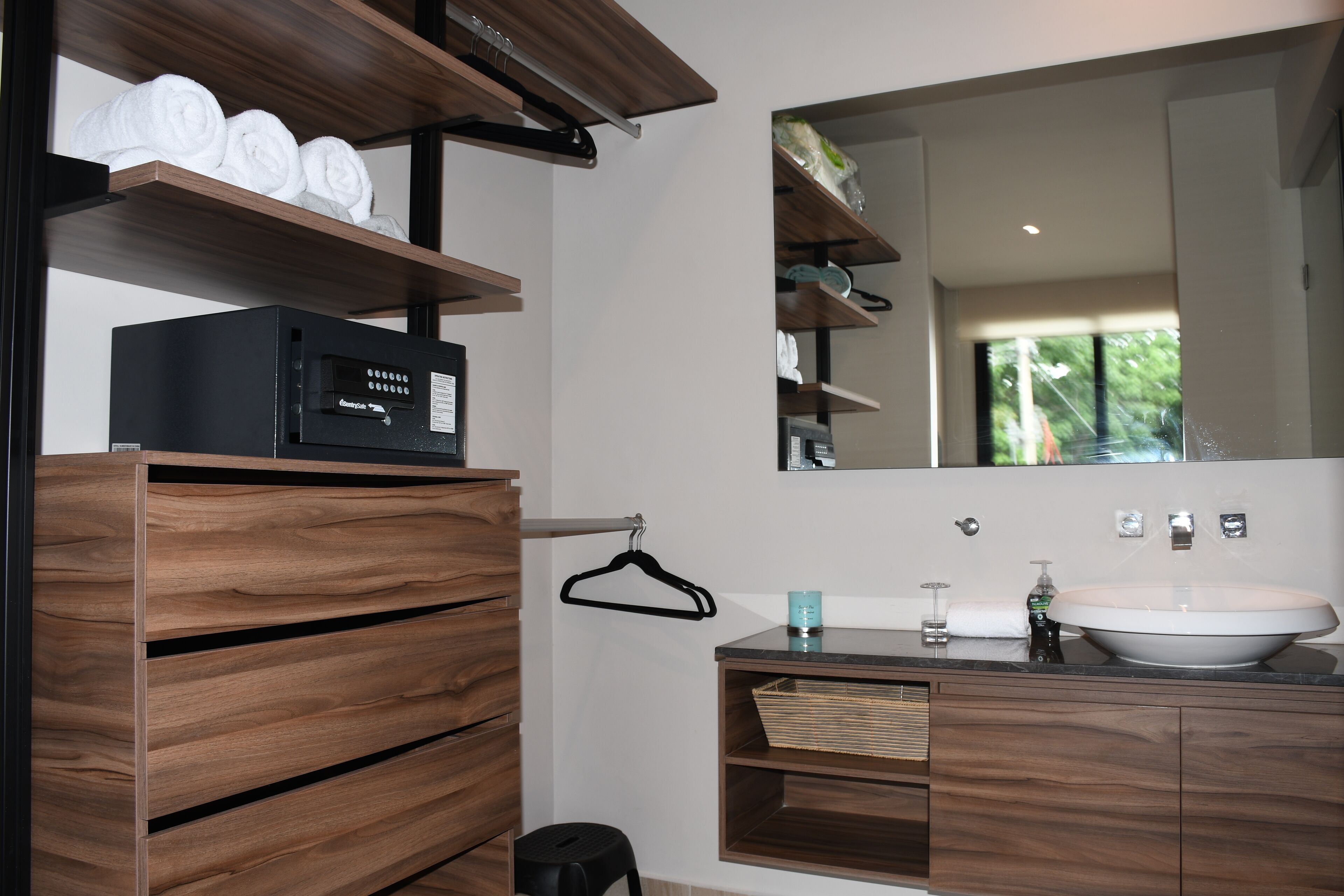 Un bagno moderno con mobili in legno, uno specchio grande e un lavabo integrato.