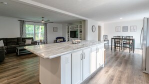 A spacious living area with a kitchen island, dining table, and seating. - Beautiful Canandaigua Lake view - Family friendly! 4 Season Home - Fall Foliage! (Canandaigua)