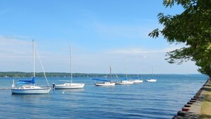 A calm waterfront with several sailboats docked along a stone pier. - Beautiful Canandaigua Lake view - Family friendly! 4 Season Home - Fall Foliage! (Canandaigua)