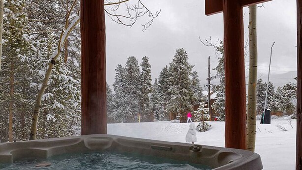 A hot tub with a snowy outdoor view.