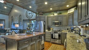 A kitchen with granite countertops, stainless steel appliances, and a large island. - Tranquility Perch | 3-State Mtn Views + Hot Tub (Murphy)