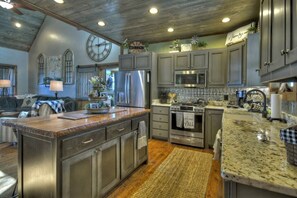 A kitchen with granite countertops, stainless steel appliances, and a large island. - Tranquility Perch | 3-State Mtn Views + Hot Tub (Murphy)
