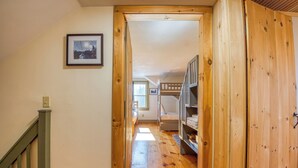 A wooden interior with a bunk bed, a framed picture on the wall, and a staircase. - Relax-Inn - Enjoy this peaceful property along Mingo Loop (Rangeley)