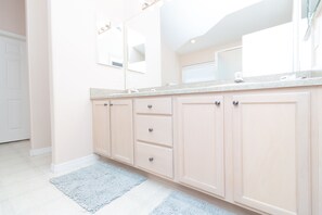 Enjoy a spacious bathroom with a large vanity, countertop, and mirror.