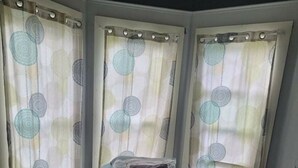 A bedroom with a bed, curtains, and a window. - #3 Bohemian Rest Place  (Watertown)
