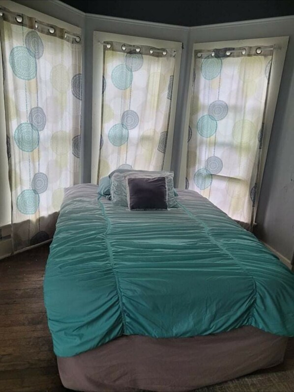 A bedroom with a bed, curtains, and a window. - #3 Bohemian Rest Place (Watertown)