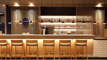 A bar area with wooden slats, a counter, and bar stools.